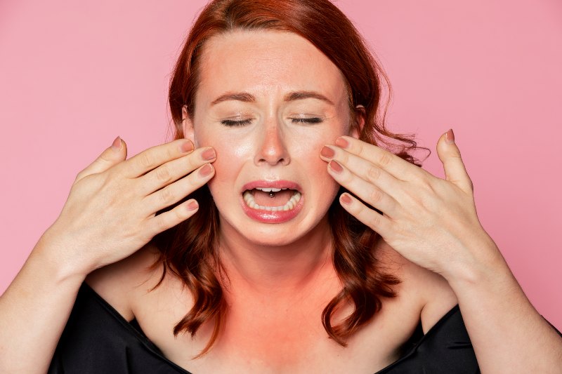woman crying over sunburnt skin