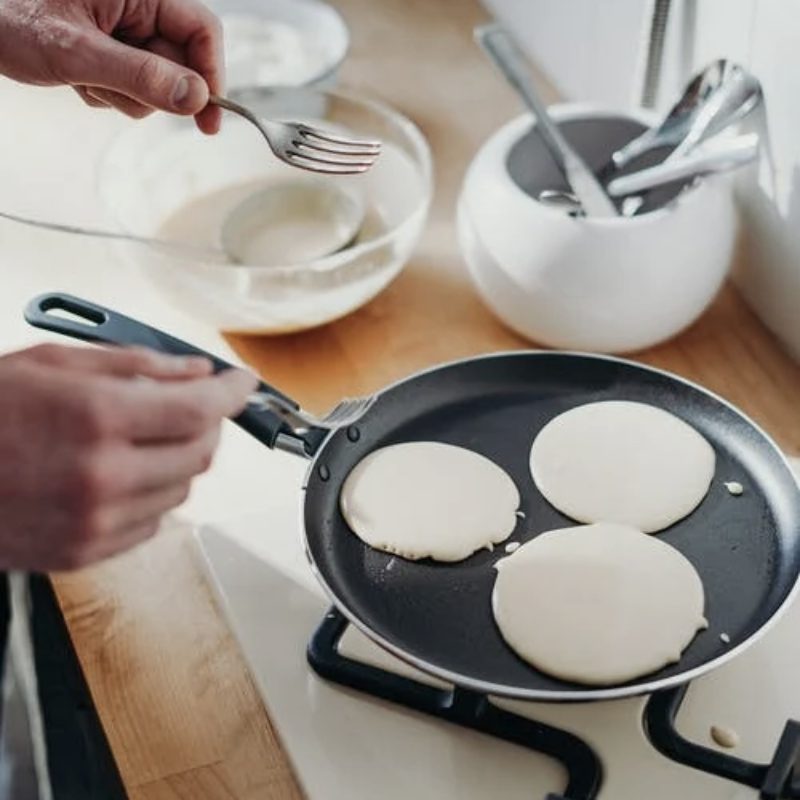 person-cooking-pancake-on-black-frying-pan