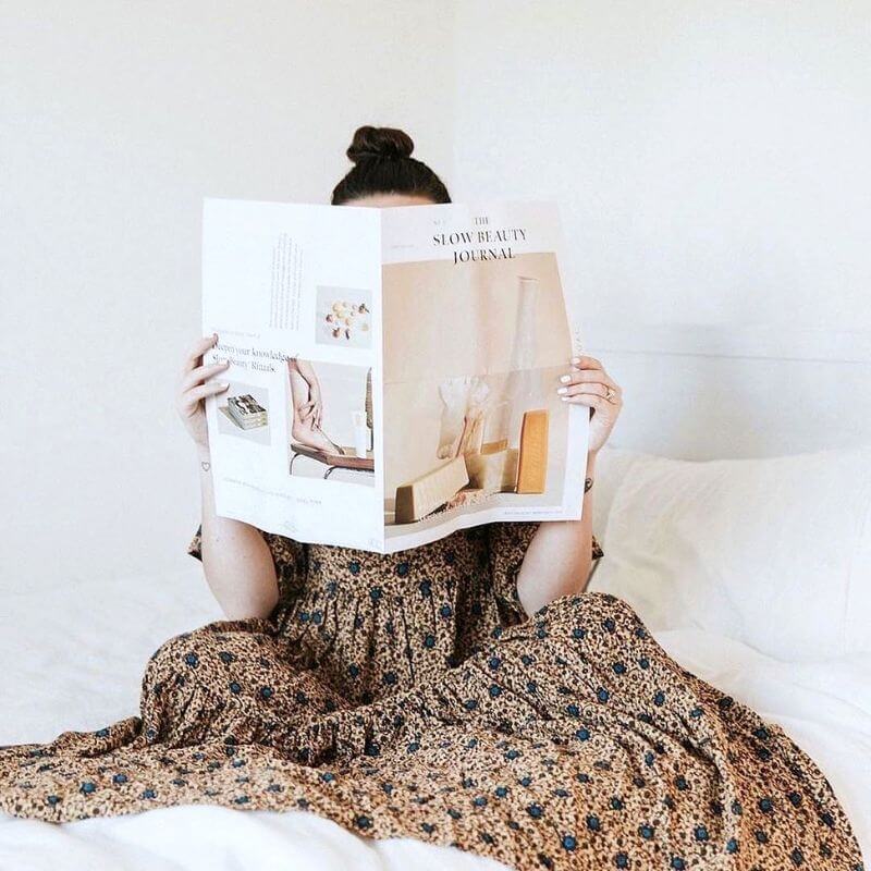 girl reading the slow beauty journal in bed