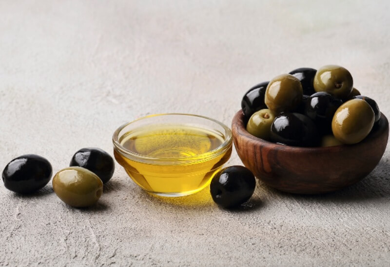 Olives fruits and virgin oil olive on a concrete background