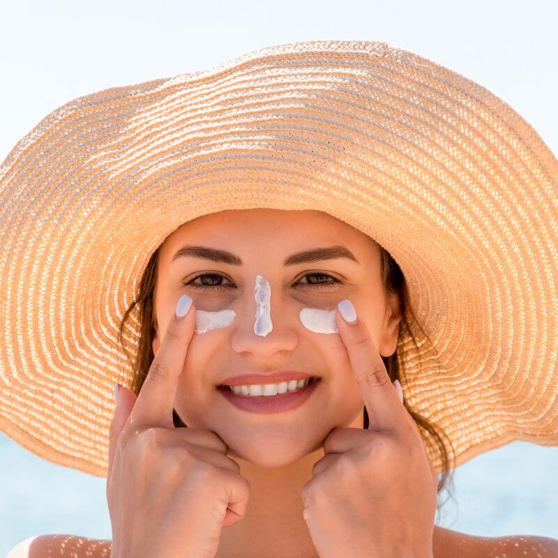 women with sunscreen on face, clean and sustainable beauty