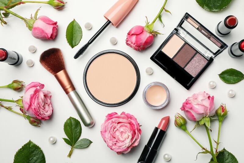 Different makeup cosmetics and flowers on white background. Female accessories